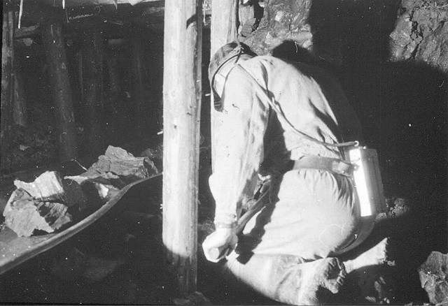 A miner is loading rocks on the conveyor !